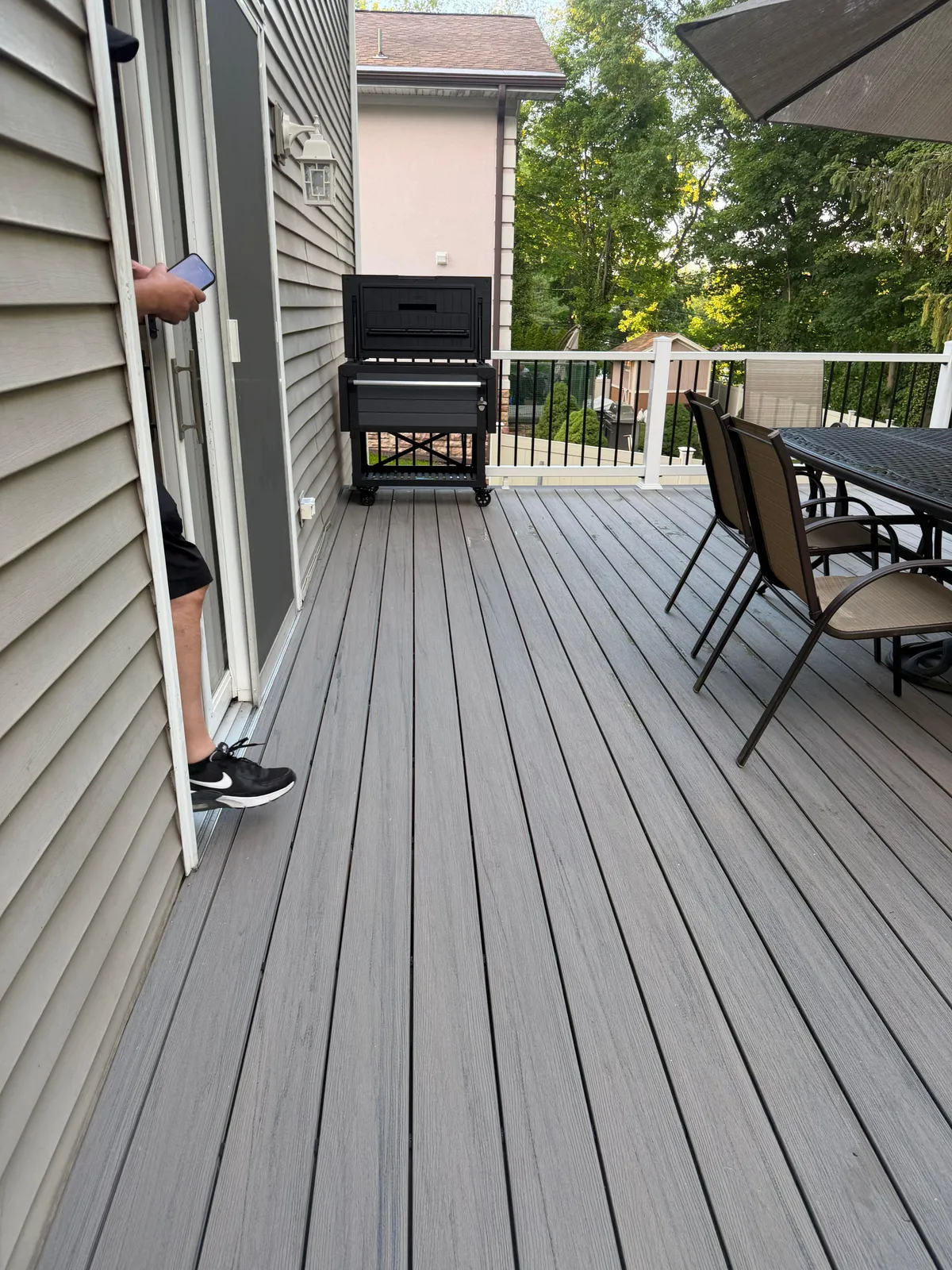 Composite Deck Boards — Gray composite deck boards with a picture-frame border, grill and patio dining set, Bergen County NJ