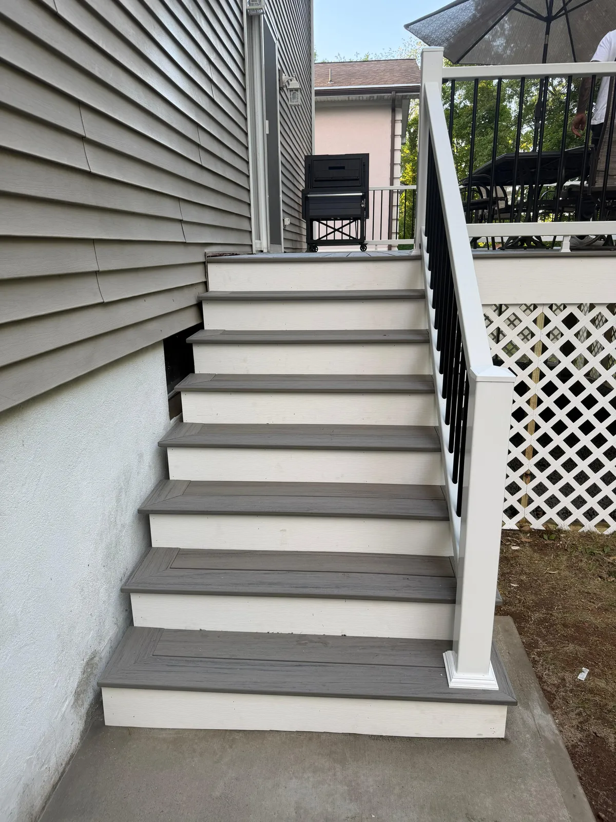 Composite Deck Stairs — Finished composite stairs with white risers, black balusters and lattice skirting, Bergen County NJ