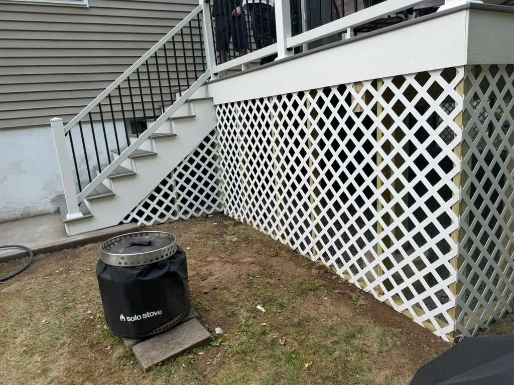 Deck Stairs & Lattice — Composite stair detail with white lattice skirting and a backyard fire pit, Bergen County NJ