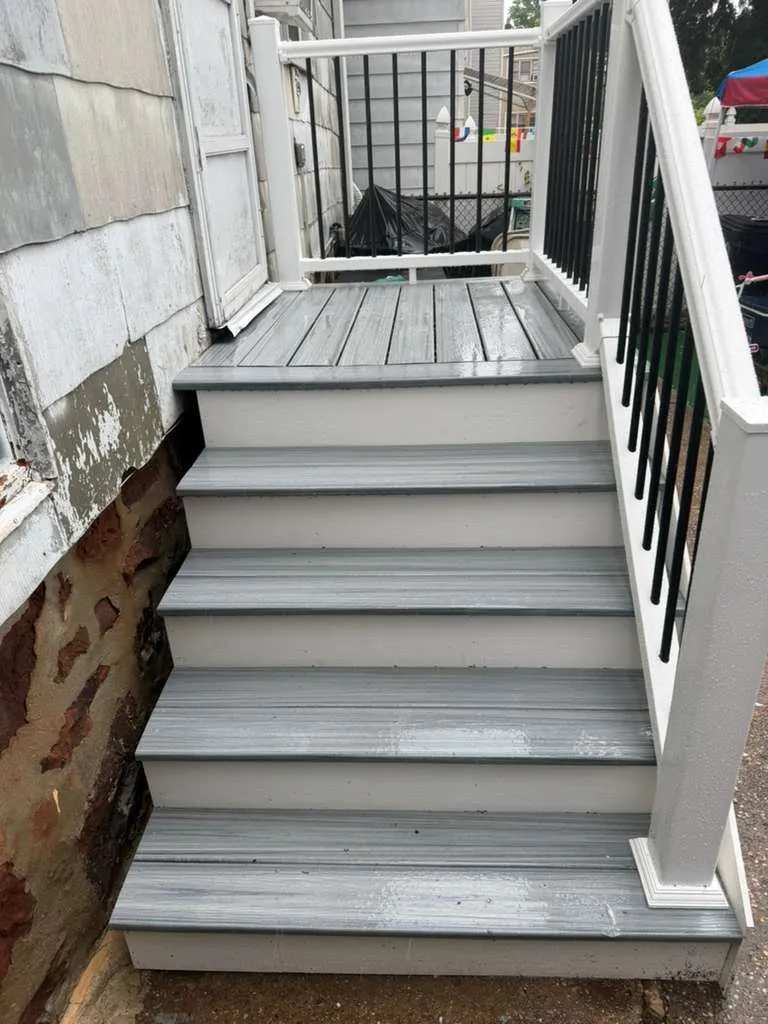 Composite Porch Stairs — New gray composite entry stairs with white risers, posts and black aluminum balusters, Bergen County NJ