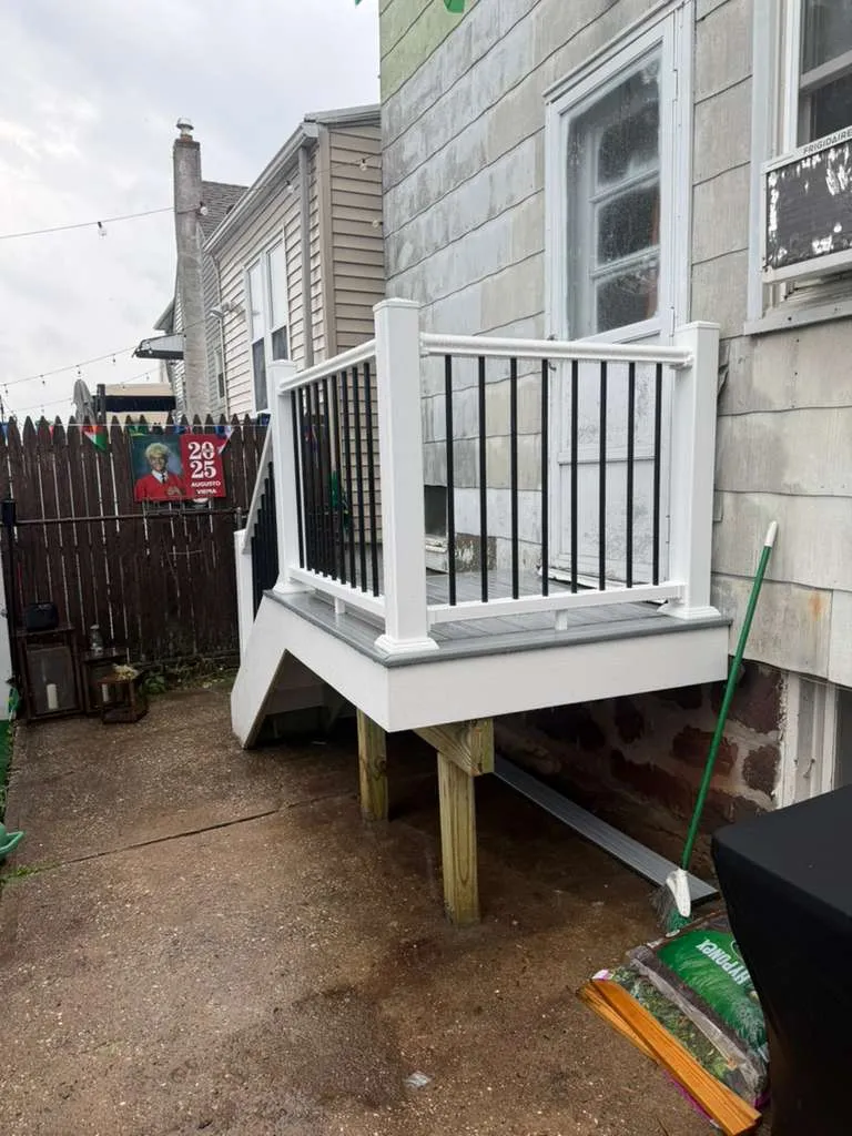 Composite Landing & Railing — Finished composite back-porch landing with a white railing and black aluminum balusters, Bergen County NJ